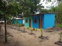 a small blue and green house with a row of trees at Pousada Grão in Belém