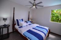a bedroom with a bed with blue and white stripes at Alyzes Diamant in Le Diamant