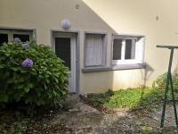 a house with a door and a window and a bush at Logement neuf en face de la forêt. Accès cour. in Bagnoles de l&#39;Orne