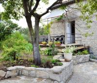 a stone house with a tree in front of it at Maison de 5 chambres avec jardin amenage a Les Vans in Les Vans
