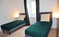 two beds in a small room with green sheets at Maison de 5 chambres avec jardin amenage a Les Vans in Les Vans