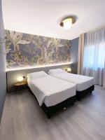 1 dormitorio con 2 camas y una pared con un mural en Hotel Astoria, en Garda