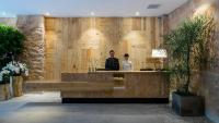 a man and a woman sitting at a counter in a lobby at Silverland Yen Hotel in Ho Chi Minh City