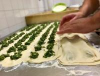 Eine Person bereitet Brokkoli in Teig auf einer Arbeitsfläche zu. in der Unterkunft MARCO APARTMENTS di Locanda da Marco in Pignone