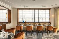 een eetkamer met tafels en stoelen en ramen bij Pavillon Faubourg Saint-Germain & Spa in Parijs