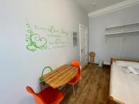 a bedroom with a wooden table and a bed at Orange Cat Rooms in Riga