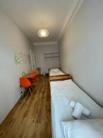 a room with two beds and a chair in it at Orange Cat Rooms in Riga