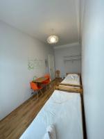 two beds in a room with a table and chairs at Orange Cat Rooms in Riga
