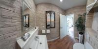 a bathroom with a white sink and a stone wall at Hotel Garni am Schloss in Kottenheim