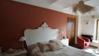 a bedroom with a bed and a red wall at Le Mas Fraissinet in Saint-Jean-de-Valériscle