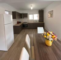 a kitchen with a table with a vase of flowers on it at FENYŐ APARTMAN HOUSE II. in Odorheiu Secuiesc