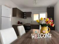 a kitchen with a table with a vase of flowers at FENYŐ APARTMAN HOUSE II. in Odorheiu Secuiesc