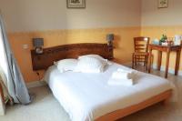 a bedroom with a large bed with white sheets and pillows at Logis Le Relais de Thézillieu in Thézillieu