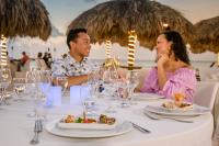 a man and woman sitting at a table with food at Amsterdam Manor Beach Resort in Palm-Eagle Beach