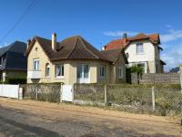 a house on the side of a street with a fence at La plage au bout du jardin &#47; Sword Beach cottage in Hermanville-sur-Mer