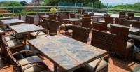 a group of tables and chairs on a patio at Hotel Roopa in Mysore