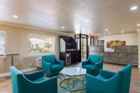 Una sala de estar con sillas azules y una mesa. en Days Inn by Wyndham Foley, en Foley