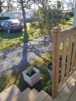 a porch with a plant in a flower pot next to a car at La Chanterie Agréable Mobil-Home Résidentiel Normand in Saint-Pair-sur-Mer