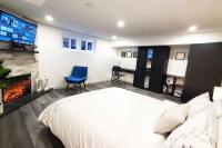 Un dormitorio con una gran cama blanca y una chimenea. en Renovated Guest Suite Near The Lake &amp; High Park in Toronto!, en Toronto