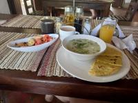 uma mesa com uma tigela de sopa e um prato de comida em Hostal Sueño Real Campestre em San Gil