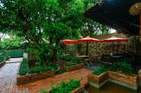 a patio with umbrellas and a table and chairs at Home Indochine d'Angkor Hotel in Siem Reap