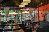 a restaurant with tables and chairs and umbrellas at Home Indochine d'Angkor Hotel in Siem Reap