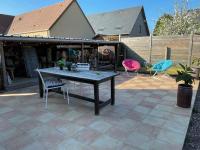 a patio with a table and chairs on a patio at Gîte Pressoir Armand in Saint Gatien des Bois