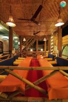 a room with a bunch of chairs and a ceiling at Tropical Wave Hostel Morjim Goa in Morjim