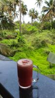 a drink in a mug sitting on a table at Tropical Wave Hostel Morjim Goa in Morjim
