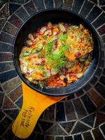a pan of food with a wooden spoon at Tiki Hut Hostel in Palomino