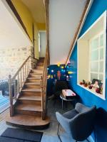 a staircase in a living room with blue walls at Chez mimie les hôtes in Fontevraud-l&#39;Abbaye