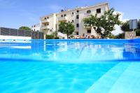 ザダルにあるHotel Mediteranの建物の前の大きなプール