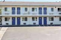 una fila de puertas azules en un edificio blanco en Motel 6-Campbell, CA - San Jose, en Campbell