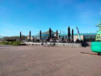 a group of people sitting outside of a building at BJ Chalets - Robbengat 68 - Gezellige chalet op vakantiepark Lauwersoog! Vroege incheck! in Lauwersoog