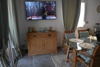 a living room with a table and a tv on the wall at appartement carqueiranne le port in Carqueiranne