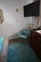 a bedroom with a tv and a blue chair at appartement carqueiranne le port in Carqueiranne