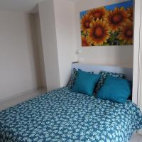 a bedroom with a bed with blue pillows and a painting at L&#39;oustal des Fontanilles in Castelnaudary