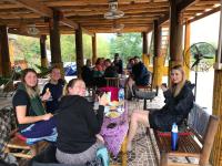 a group of people sitting at tables in a pavilion at Nha Tan - Mai Chau Homestay & Tours in Mai Châu
