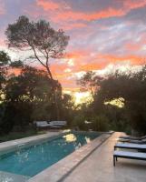 a swimming pool with a sunset in the background at La Villa Kallisté in Vacquières