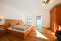 a bedroom with a bed with a wooden headboard at Ferienwohnungen Wartbichler in Lofer