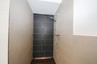 a bathroom with a shower with black tiles at Ferienwohnungen Wartbichler in Lofer