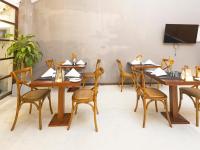 una sala da pranzo con tavoli e sedie in legno di Heritage Boutique by Seven Angels a Kandy