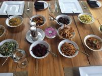 una mesa de madera con muchos tazones de comida. en NIKARA Luxury Beach House, en Tissamaharama