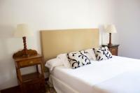 a bedroom with two white beds and two lamps at Hotel Hacienda Montenmedio in Vejer de la Frontera