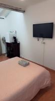 1 dormitorio con 1 cama y TV de pantalla plana en la pared en Chambre cosy, en Arles