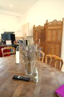 a vase of flowers sitting on a table with a remote control at Camping Arbre de Vie in Montagnac
