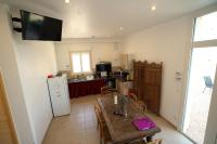 a kitchen with a table and a refrigerator at Camping Arbre de Vie in Montagnac
