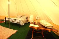 a bedroom with a bed and a table in a tent at Camping Arbre de Vie in Montagnac