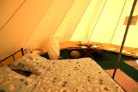 a tent with a bed and a table in it at Camping Arbre de Vie in Montagnac