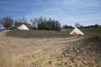 two tents in a field next to a house at Camping Arbre de Vie in Montagnac
